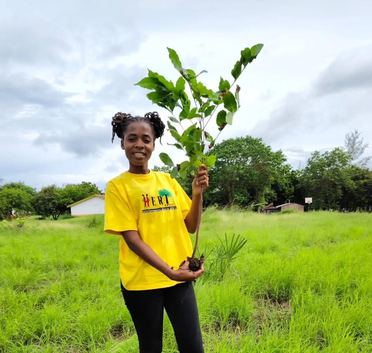 A HERI eco-club member holds up a tree seedling ready for planting